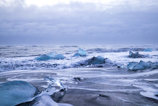 iceberg pieces break off and float from the Jokulsarlon Glacier to Diamond Beach, Iceland