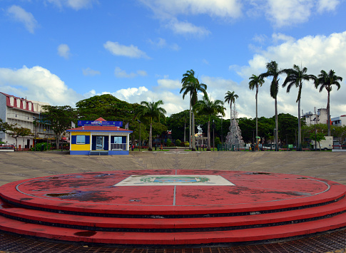 Pointe-à-Pitre, Grande-Terre, Guadeloupe: Victory Square (Place de la Victoire) - the main public square in the city, platform with the city's coat of arms, displaying a shield bearing a tower with the French flag, abutted by two bridges and three fleur de lis, framed by laurel leaves and placed over crossed anchors. Tourist information office on the left.