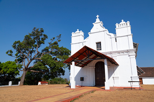 This image beautifully captures the Three Kings Chapel, perched atop Cansaulim Hill in Goa. This quaint and serene chapel is known for its panoramic views of the surrounding landscape and the Arabian Sea. Its simple yet elegant architectural style is a testament to Goa's rich religious and cultural history. The chapel, often bathed in the warm glow of the Goan sun, stands as a peaceful retreat and a popular destination for both locals and tourists. The photograph aims to convey the tranquil and spiritual atmosphere of the chapel, set against the stunning backdrop of Goa's natural beauty, making it a unique and must-visit spot in the region.