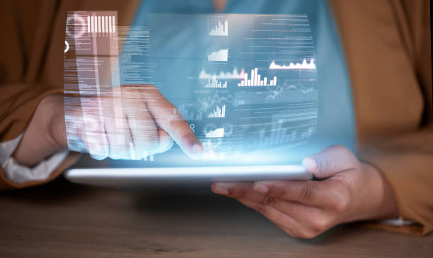 istock Data tablet hologram, global analytics and hands working on futuristic software in the dark. Finance database, virtual overlay and financial website work at night with a user and focus at office 1799336604