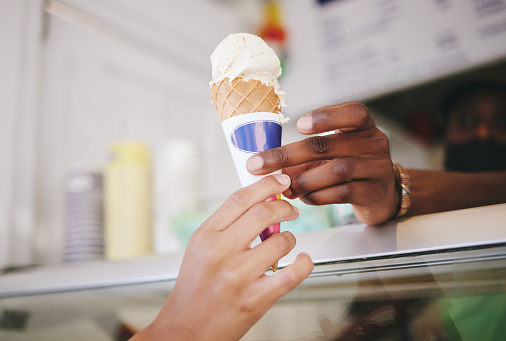 Hands, ice cream and woman buying icecream cone at a shop, local and small business support. Sugar, dessert and person purchase snack from seller to enjoy on summer day as a frozen sweet in the city