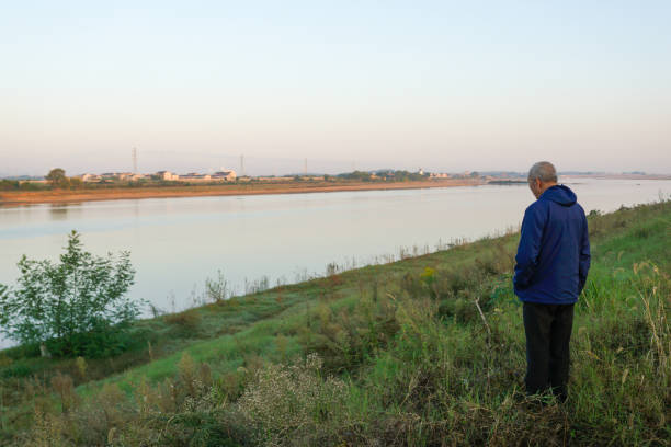 istock old man standing in front of the river 1799414443