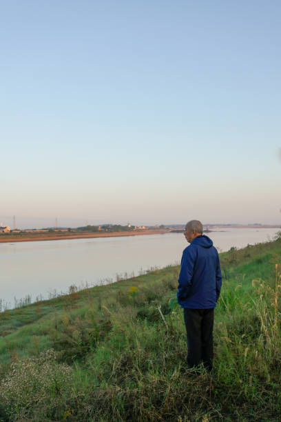istock old man standing in front of the river 1799416012