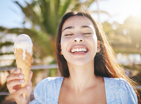 Ice cream, dessert and woman with smile on holiday in Miami during summer. Face of happy, excited and young girl eating sweet food or gelato on travel vacation in the urban city during spring