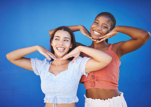 istock Smile, beauty and friends with smile and comic hands against a blue mockup studio background together. Portrait and thinking face of black woman and girl being happy and funny with a gesture 1799464028
