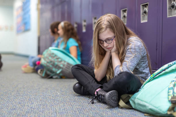 istock Young student sits on floor in front of lockers 1799467884