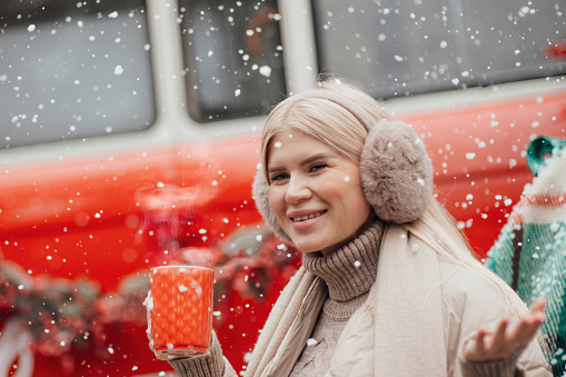 Smiling active pregnant woman rest relax enjoying cold frosty snowy weather waiting for birth of child.Celebrating Christmas and New Year winter holidays season outside at forest near Xmas red old bus