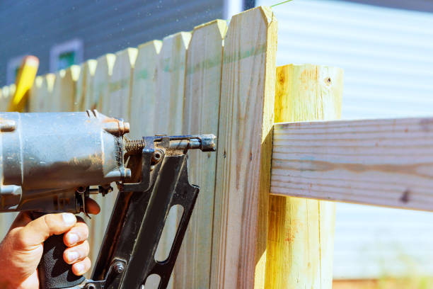 istock By using an air nail gun, he constructs sections of a wooden fence around his yard 1799490888