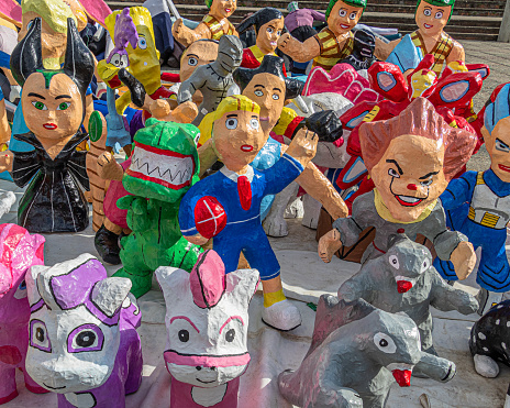 Cuenca, Ecuador - December 29, 2022: Paper mache dolls or Monigotes depicting different heroes and characters for sale in a street market to be burn out  at midnight to celebrate New Year
