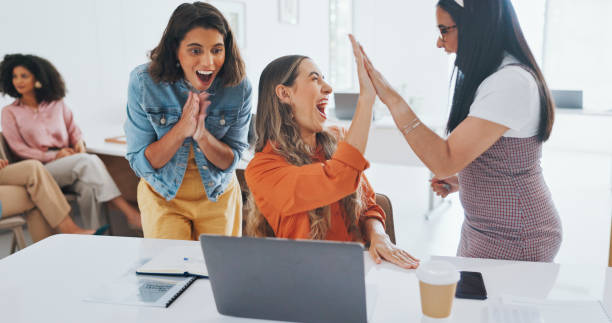 istock Support, teamwork and high five with business people and laptop for bonus, celebration or winner. Promotion, growth and target with women and cheers in office for achievement, profit or goal together 1799503768