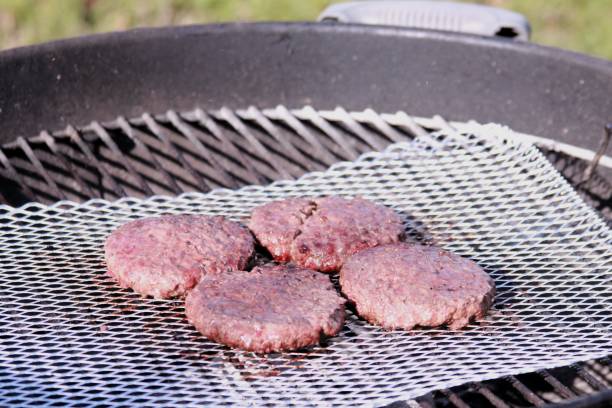 istock Four burger patties barbeque on the grill 1799583081