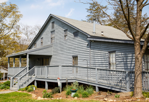 An old grey wood siding house with a wheelchair accessible ramp