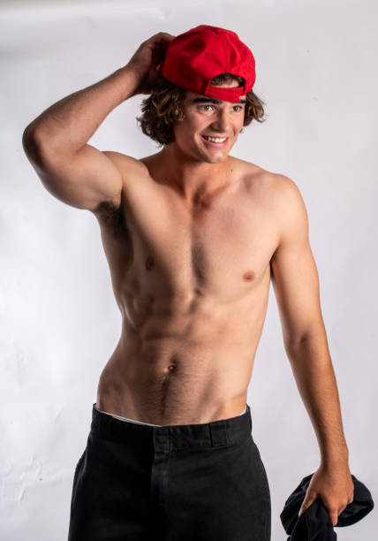 istock good looking young man prepares to go surfing. 1799619509