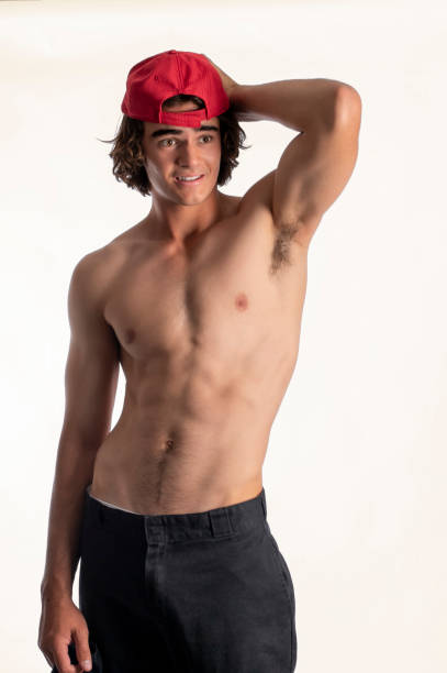 istock good looking young man prepares to go surfing. 1799620021