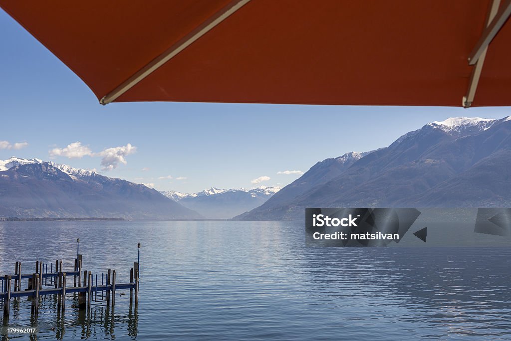 Alpine lake with parasol Alpine lake with snow-capped mountain under a parasol in switzerland Sunshade Stock Photo