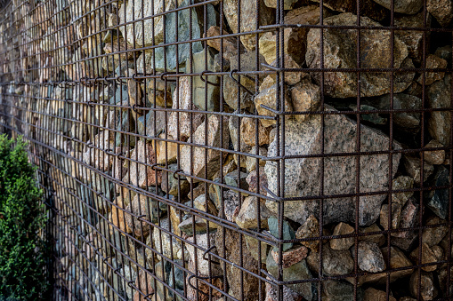 Metal cage containing rocks to build a sustainable wall.