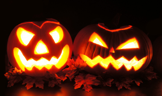 Spooky Halloween Jack o Lanterns with leaves at night