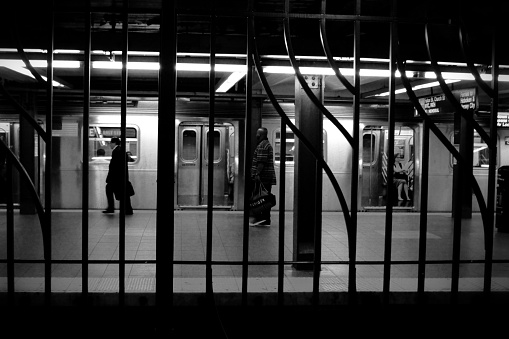 Passengers get on to the subway behind the bars in the subway of New York city