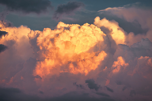 Cumulonimbus clouds fill the sky as a thunderstorm develops at sunset.