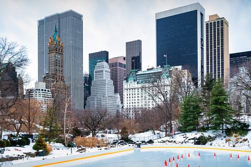 Central Park skating rink and skyline in New York City during Winter.