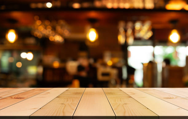 istock Empty wooden table top with lights bokeh on blur restaurant background. 1799714523