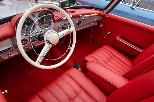 Interior of a classic vintage car, red leather.