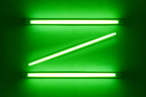 istock green neon bulbs on white wall. Background texture of empty old wall with glowing green neon bulbs. 1799733272