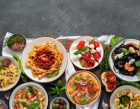 Italian food dishes on dark background. Traditional food concept. Top view, copy space.