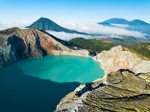 Aerial view of rock cliff at Kawah Ijen volcano with turquoise sulfur water lake at sunrise.Amazing nature landscape view at East Java, Indonesia.Natural landscape background