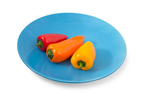 istock Three small colorful peppers on a blue plate 179981961