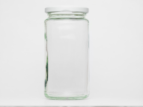 Empty glass jar on white background in studio. No people.