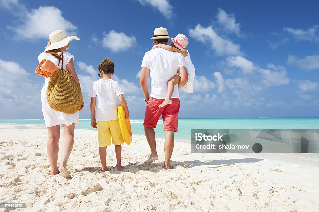 Family beach vacation Back view of a happy family on tropical beach Beach Stock Photo