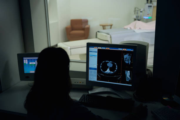 istock Radiologic technologist conducting computed tomography scanning in control room 1799926777