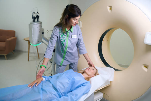 istock Focused radiographer preparing female client for computed tomography in clinic 1799927401