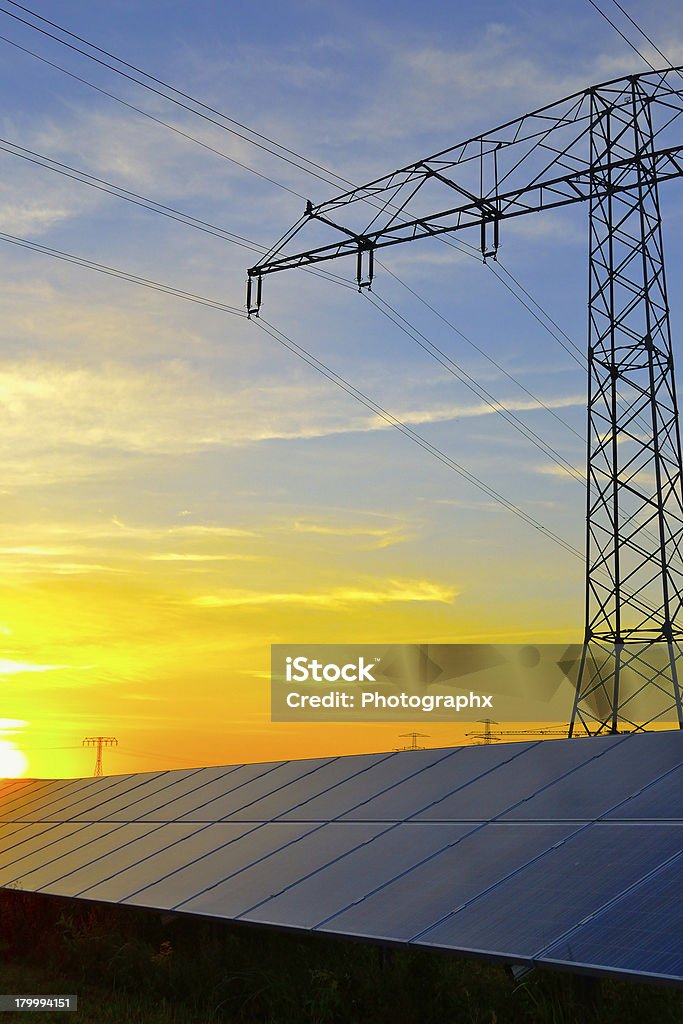 光起電性パネルや、夕暮れ時の送電鉄塔 - グ��リーンテクノロジーのロイヤリティフリーストックフォト