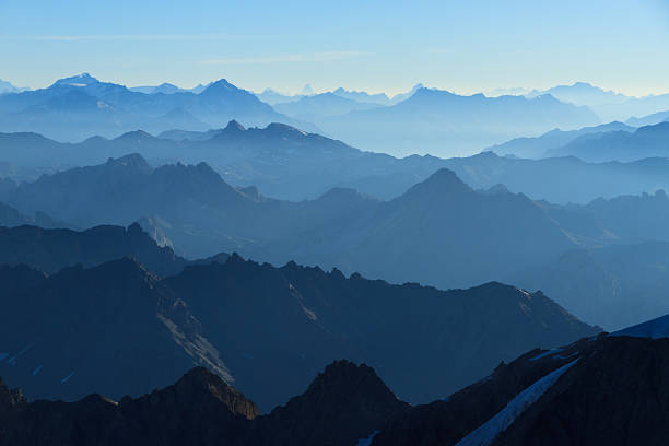 Blue layers of mountains Stunning panorama in the Alps with a majestic view on the high peaks of the Ecrins Massif National Park, France. dark blue mountain stock pictures, royalty-free photos & images