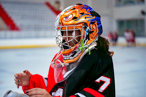 helmeted female ice hockey player prepares for the match