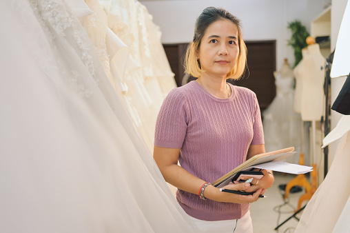 SME business owner second hand wedding studio online store using digital tablet for online platform