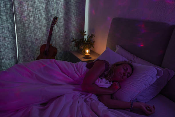 istock Woman getting some rest in bed with special night mood lights 1800019260