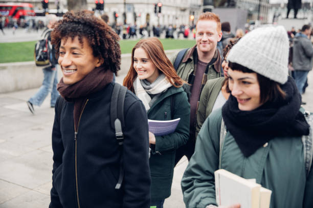 Group of multi ethnic students friends walking to university in UK.