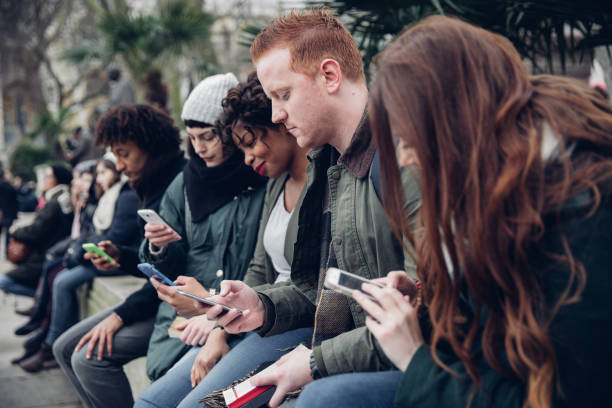istock Group of multi ethnic students friends sitting and using their smartphones 1800029517
