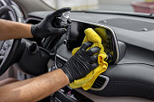 Hand cleaning the car interior with microfiber cloth towel