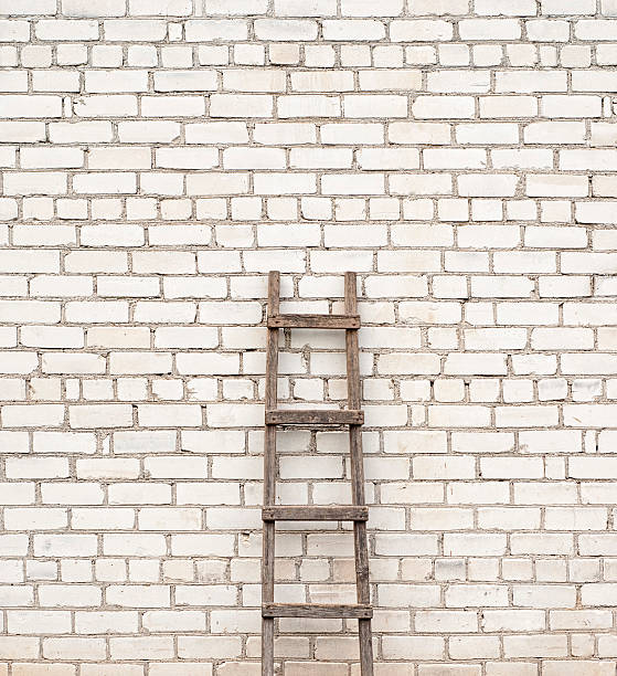 istock ladder near the brick wall background 180012367