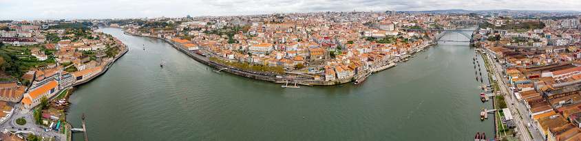 Panoramic aerial view of Porto city. View of Douro River. At right is Dom Luis I Bridge, at left Ponte da Arrabida. Panoramic perspective of old town center. Cloudy day. Famous travel destination.