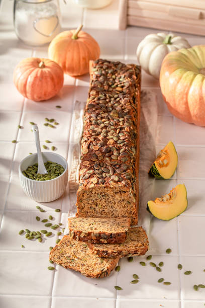istock Fresh pumpkin bread with orange squashes and seeds. 1800139847