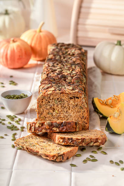 istock Delicious pumpkin bread with orange squashes and seeds. 1800143911