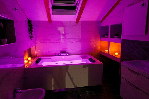 The interior design of a modern bathroom in pink neon light