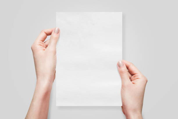 istock Two Hands Holding an A5 Paper on Grey Background 1800198693