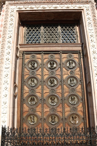 Budapest, B, Hungary - August 19, 2023: wooden gate with faces at St Stephen s Basilica in Budapest  Hungary