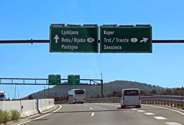 リュブリャナに到達するか、イタリアの国境とトリエステの街に向かうためのスロベニアの高速道路の道路標識 - pullman car ストックフォトと画像